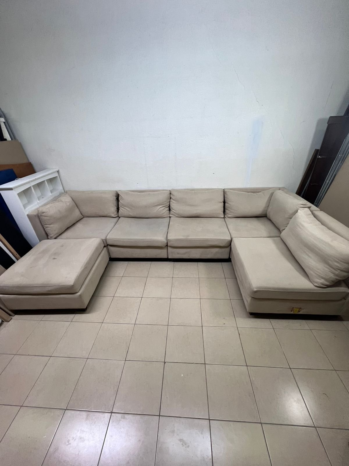A spacious, modern, U-shaped sectional sofa in a calm beige color with a footrest. - Image 7