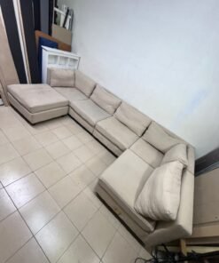 A spacious, modern, U-shaped sectional sofa in a calm beige color with a footrest. - Image 8