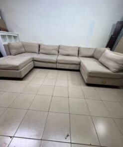 A spacious, modern, U-shaped sectional sofa in a calm beige color with a footrest. - Image 9