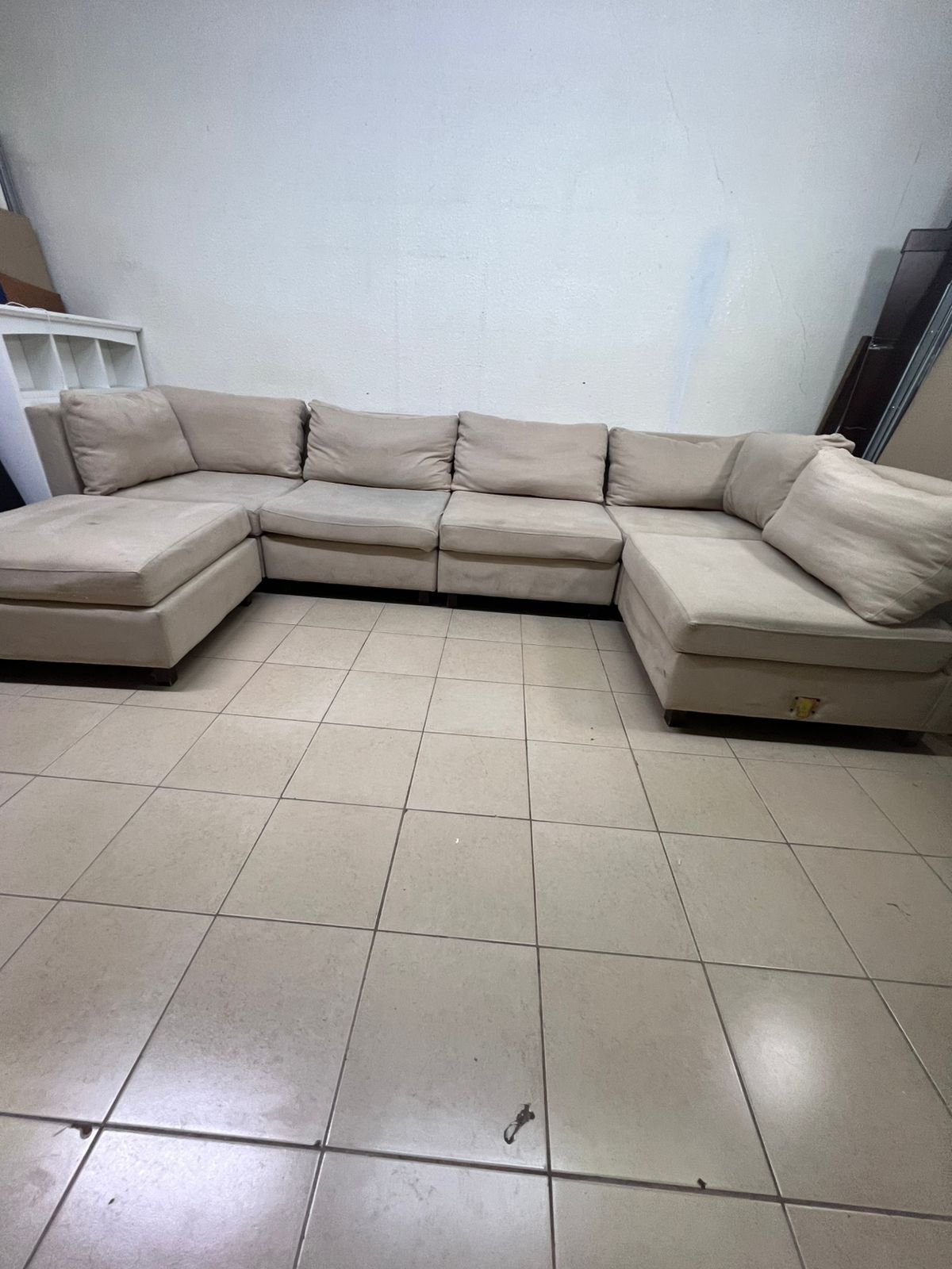 A spacious, modern, U-shaped sectional sofa in a calm beige color with a footrest. - Image 9