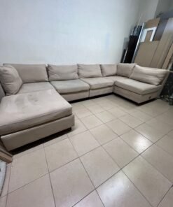 A spacious, modern, U-shaped sectional sofa in a calm beige color with a footrest. - Image 10