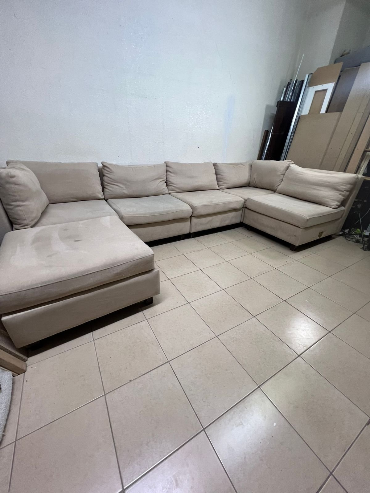 A spacious, modern, U-shaped sectional sofa in a calm beige color with a footrest. - Image 10