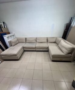 A spacious, modern, U-shaped sectional sofa in a calm beige color with a footrest. - Image 11