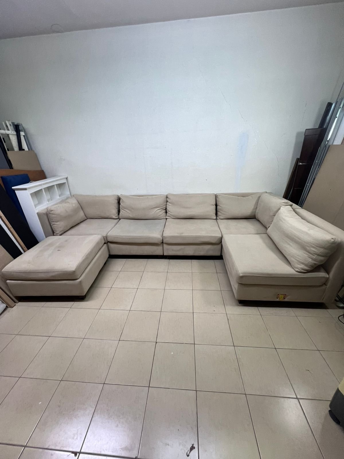 A spacious, modern, U-shaped sectional sofa in a calm beige color with a footrest. - Image 11
