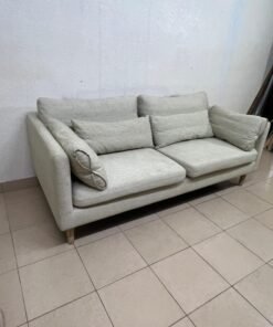 A spacious light beige fabric sofa with back cushions and additional long, square cushions. - Image 5