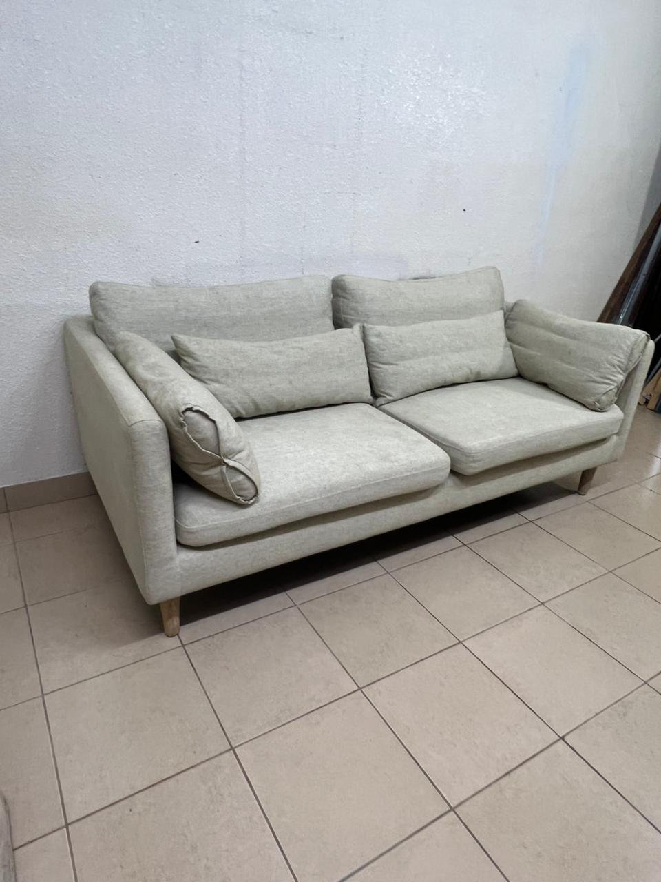 A spacious light beige fabric sofa with back cushions and additional long, square cushions. - Image 5