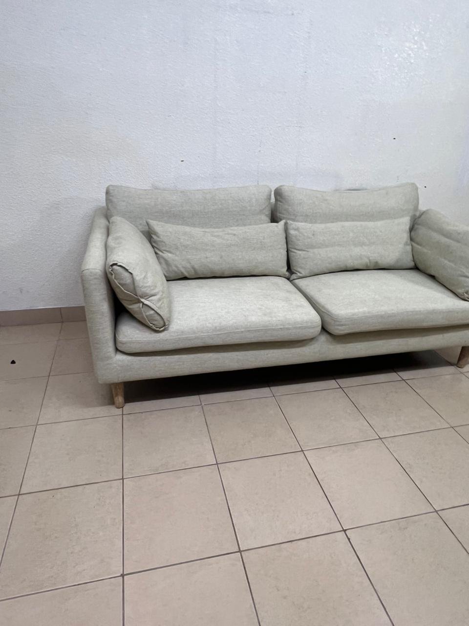 A spacious light beige fabric sofa with back cushions and additional long, square cushions. - Image 8
