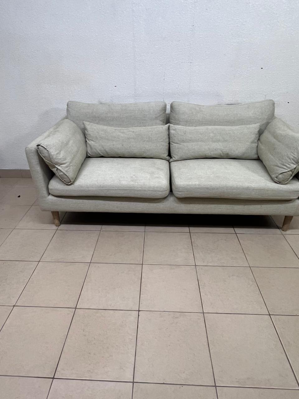 A spacious light beige fabric sofa with back cushions and additional long, square cushions. - Image 2