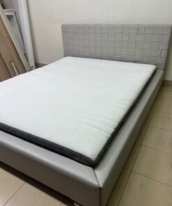 Grey double bed frame with upholstered design and distinctive headboard.
