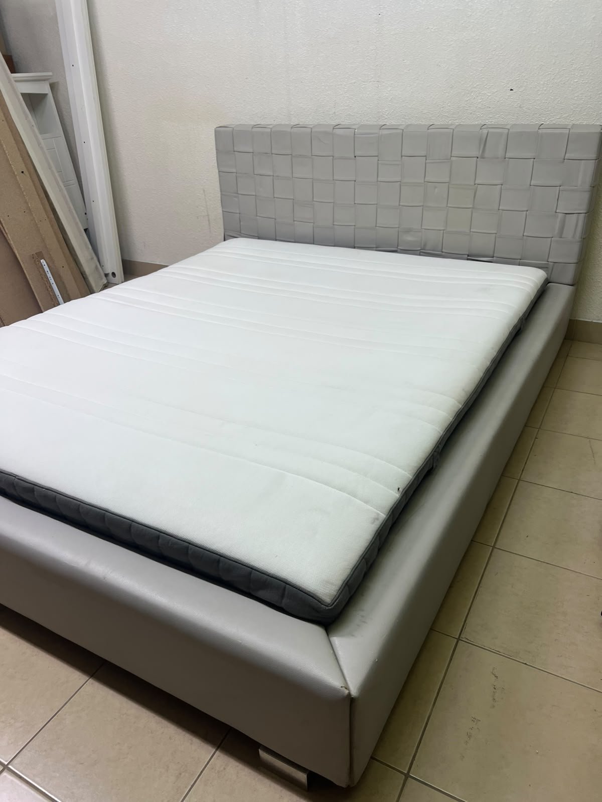 Grey double bed frame with upholstered design and distinctive headboard.