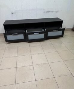 The television unit shown in the picture is a modern black TV stand with three drawers featuring opaque glass fronts and open shelves for appliances. - Image 5