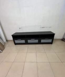 The television unit shown in the picture is a modern black TV stand with three drawers featuring opaque glass fronts and open shelves for appliances. - Image 6