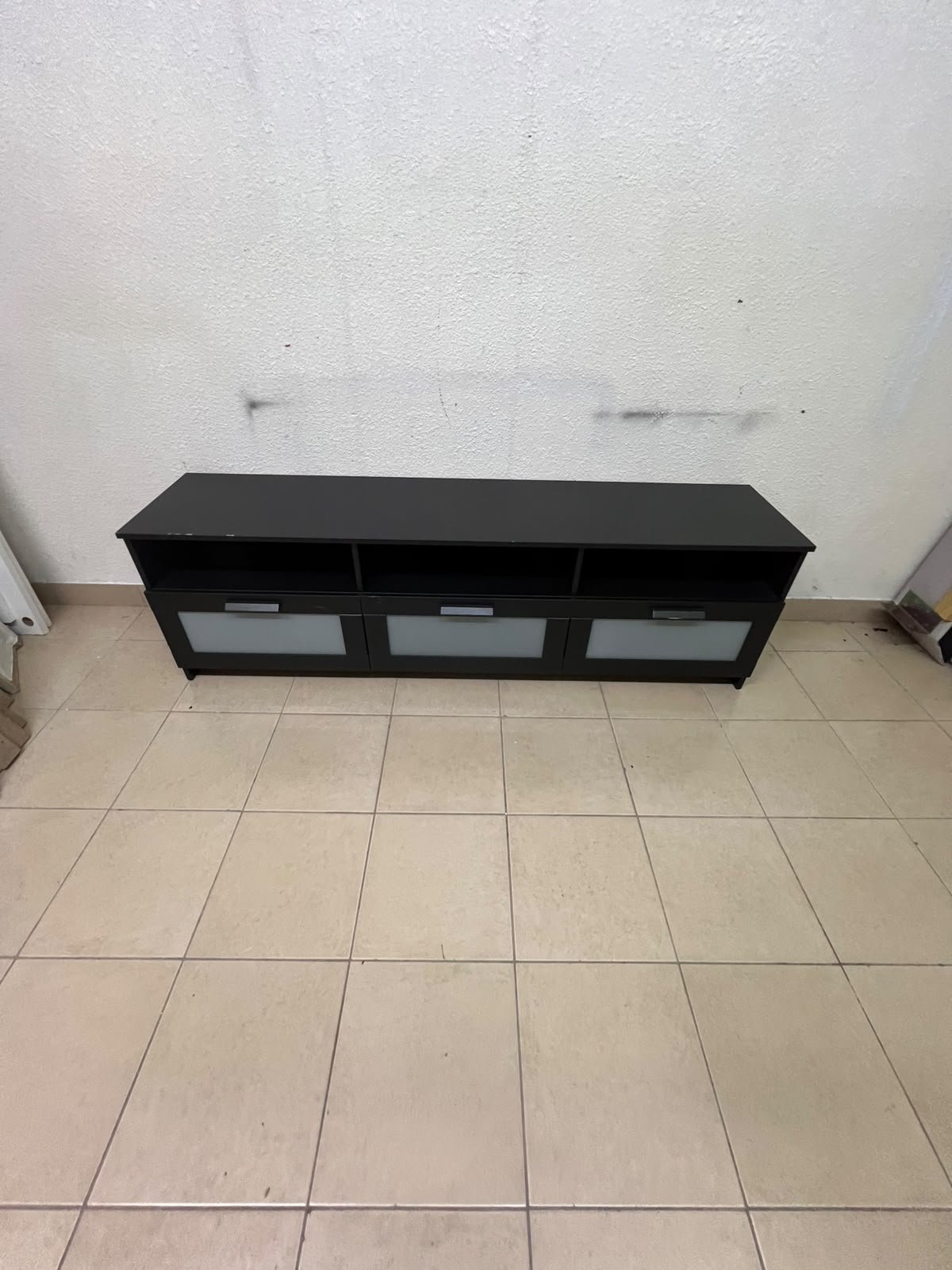 The television unit shown in the picture is a modern black TV stand with three drawers featuring opaque glass fronts and open shelves for appliances. - Image 7