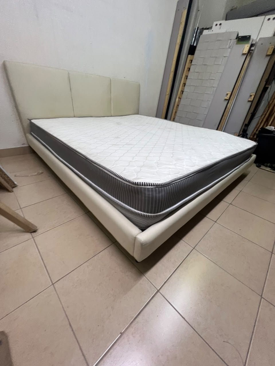 Double bed with a light beige upholstered design, featuring a split headboard and a white mattress with gray and black edges. - Image 2