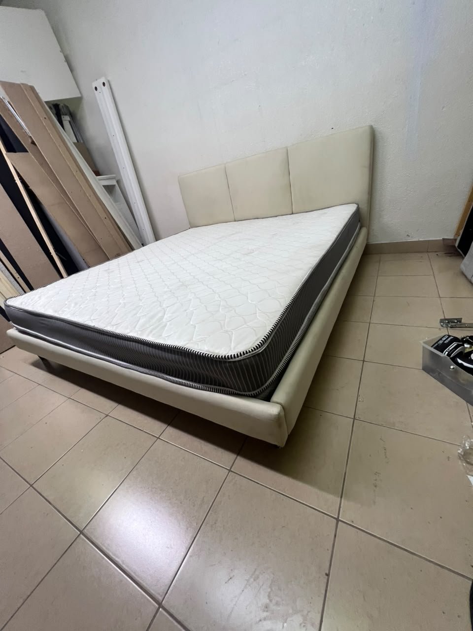 Double bed with a light beige upholstered design, featuring a split headboard and a white mattress with gray and black edges. - Image 5