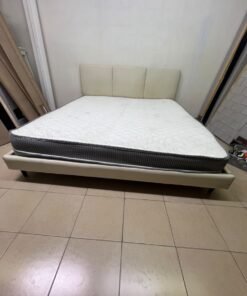 Double bed with a light beige upholstered design, featuring a split headboard and a white mattress with gray and black edges. - Image 11