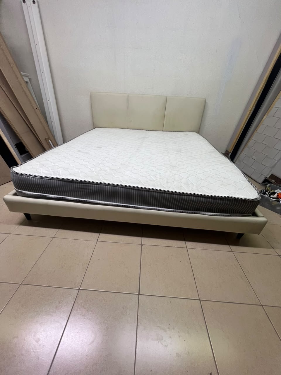 Double bed with a light beige upholstered design, featuring a split headboard and a white mattress with gray and black edges. - Image 11