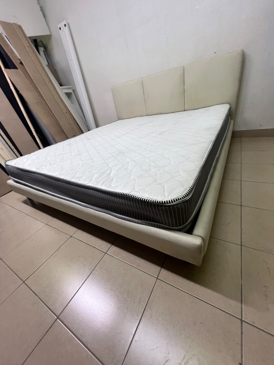 Double bed with a light beige upholstered design, featuring a split headboard and a white mattress with gray and black edges. - Image 10