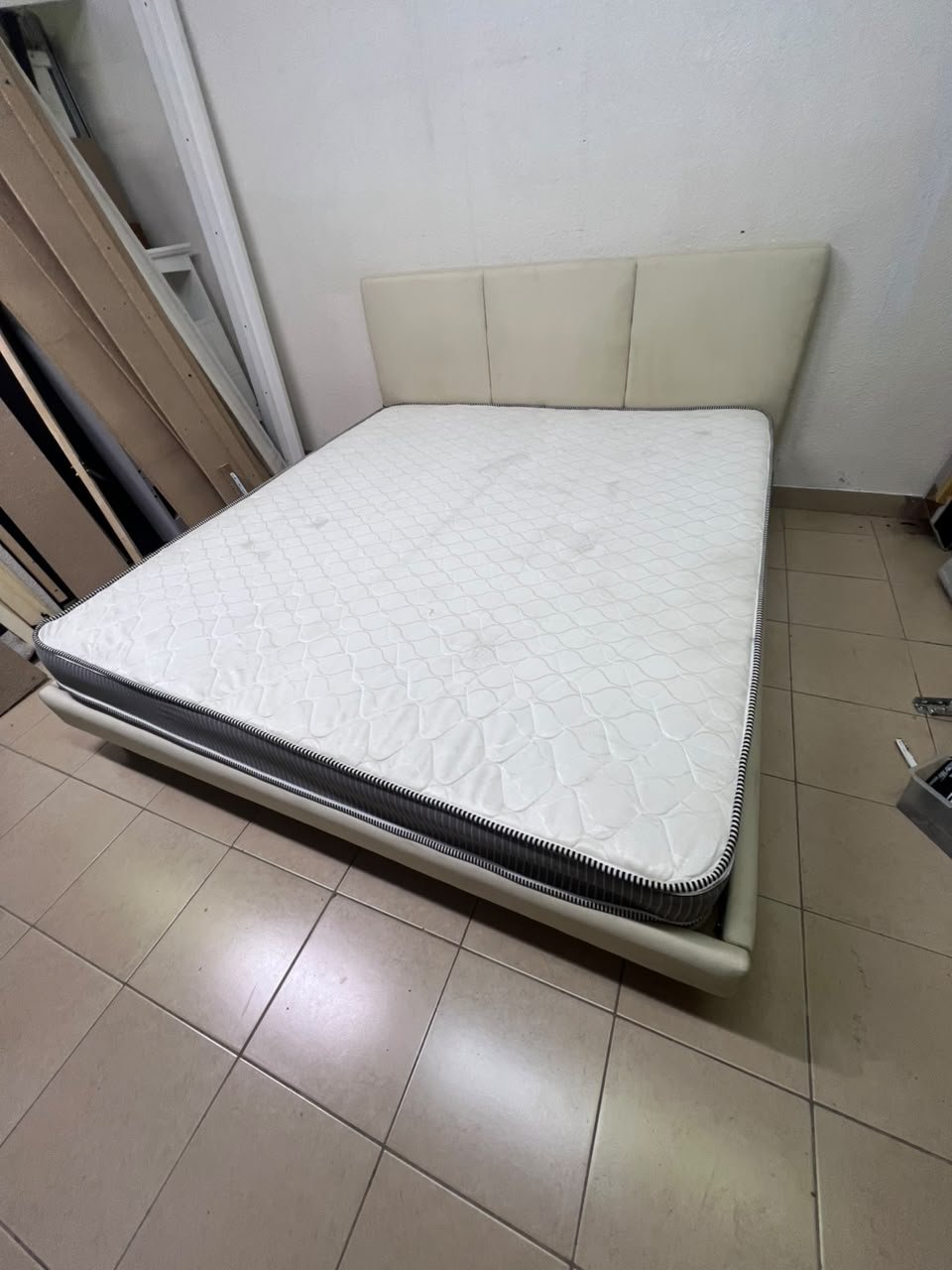 Double bed with a light beige upholstered design, featuring a split headboard and a white mattress with gray and black edges. - Image 9