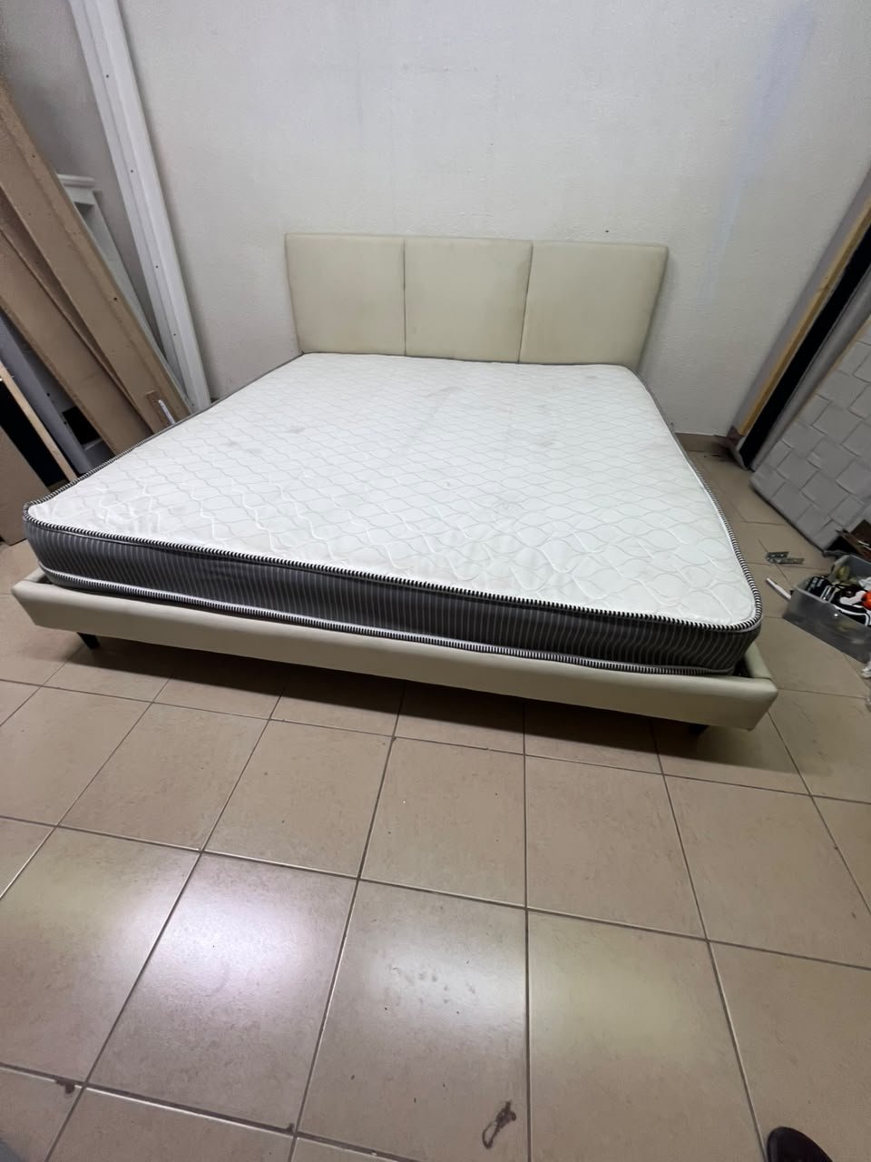 Double bed with a light beige upholstered design, featuring a split headboard and a white mattress with gray and black edges. - Image 8