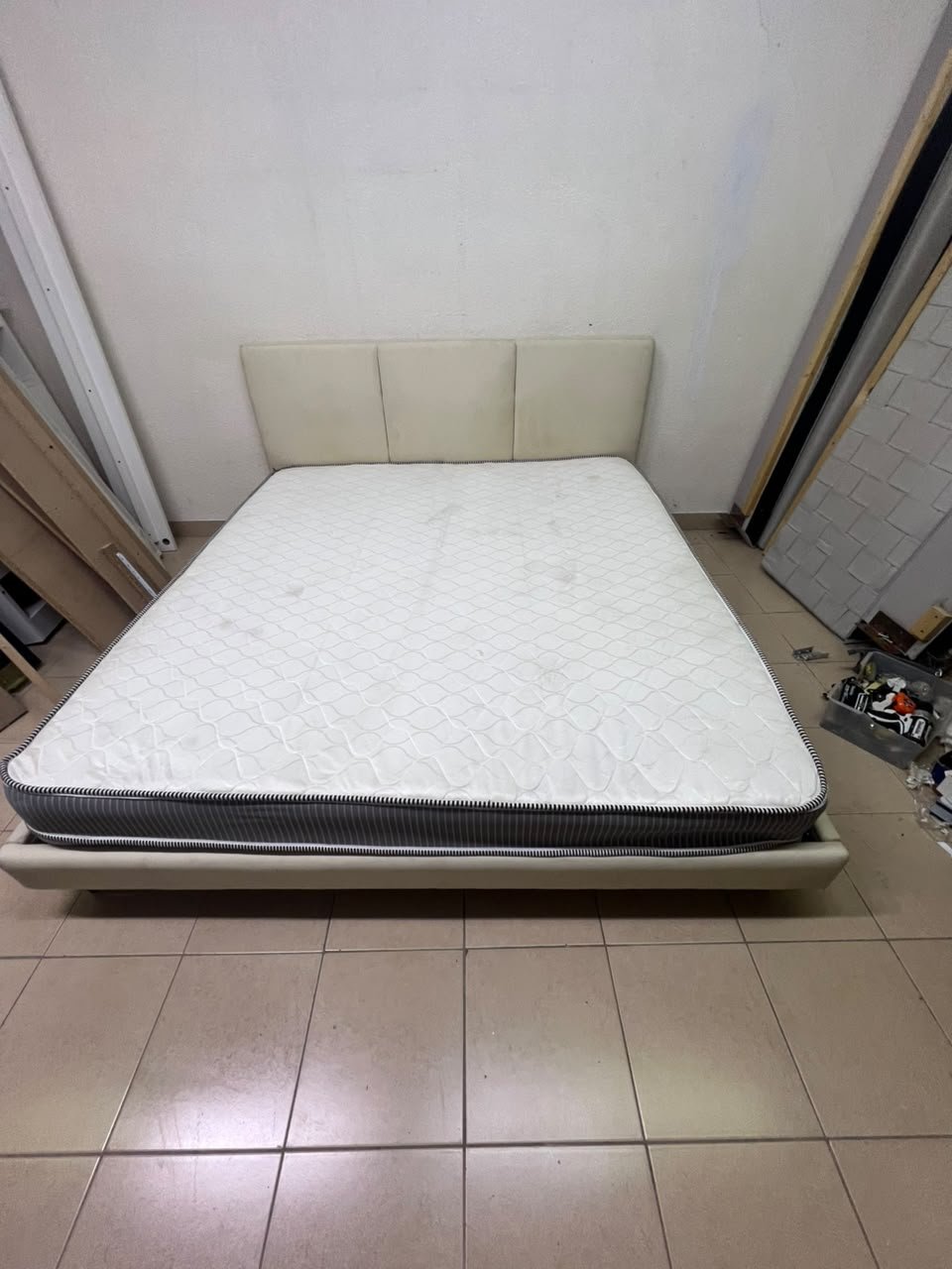 Double bed with a light beige upholstered design, featuring a split headboard and a white mattress with gray and black edges. - Image 7