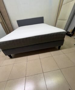 A gray upholstered bed frame with a white mattress and blanket, or a dark gray mattress on the side. - Image 2