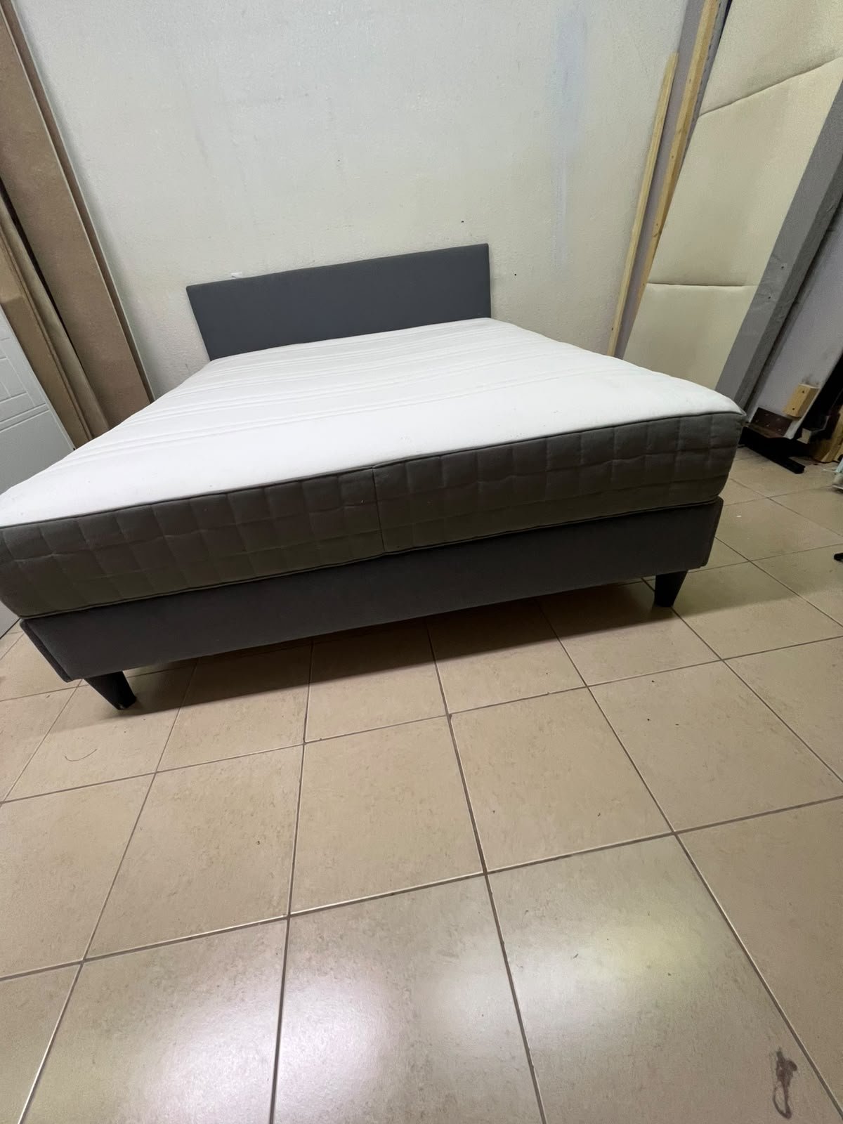 A gray upholstered bed frame with a white mattress and blanket, or a dark gray mattress on the side. - Image 2