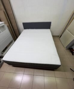 A gray upholstered bed frame with a white mattress and blanket, or a dark gray mattress on the side. - Image 3