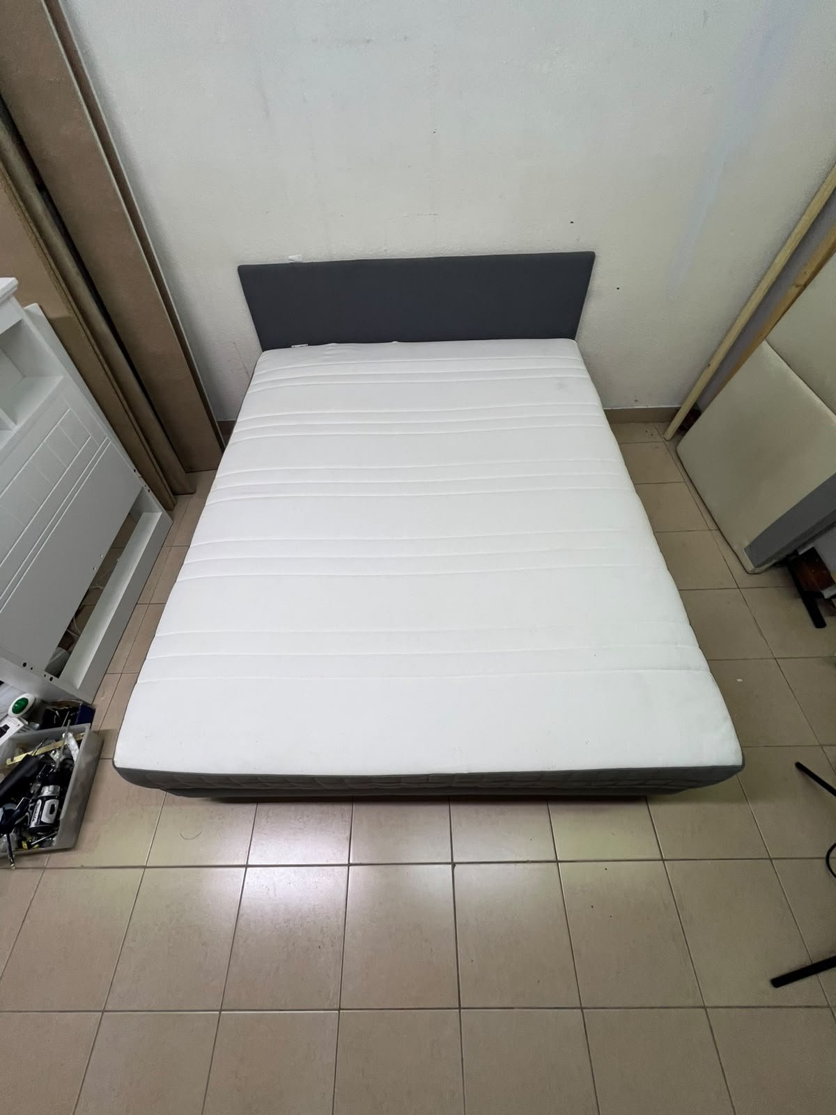 A gray upholstered bed frame with a white mattress and blanket, or a dark gray mattress on the side. - Image 4