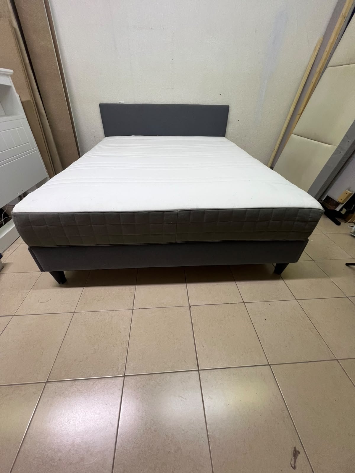 A gray upholstered bed frame with a white mattress and blanket, or a dark gray mattress on the side. - Image 6