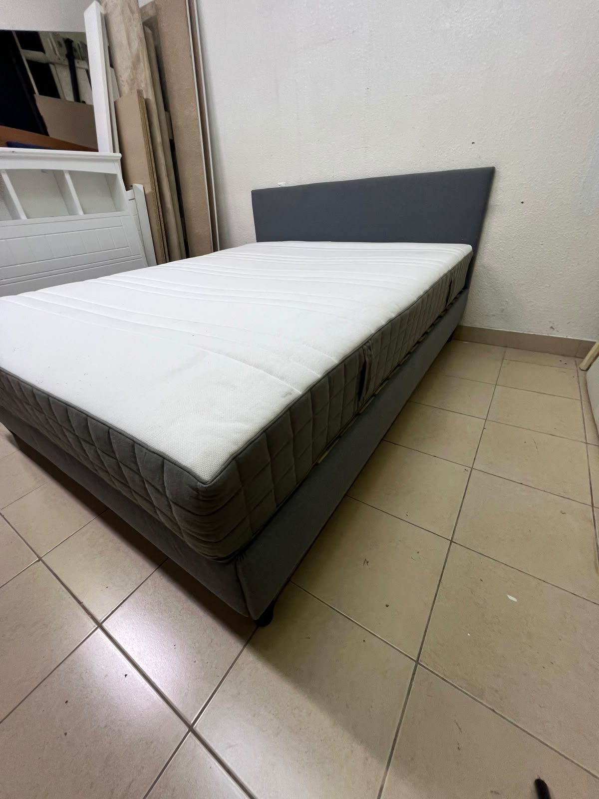 A gray upholstered bed frame with a white mattress and blanket, or a dark gray mattress on the side. - Image 7