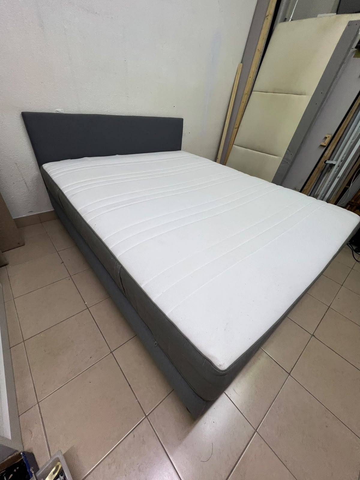A gray upholstered bed frame with a white mattress and blanket, or a dark gray mattress on the side. - Image 8