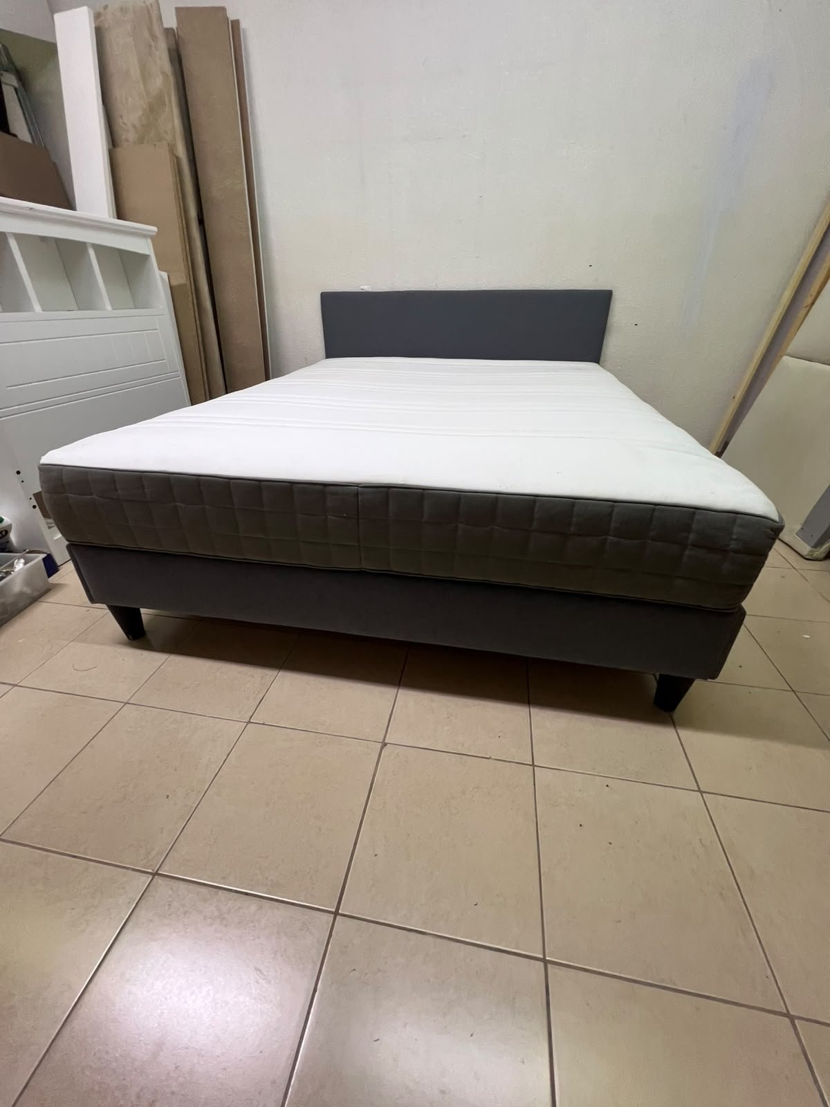 A gray upholstered bed frame with a white mattress and blanket, or a dark gray mattress on the side. - Image 9