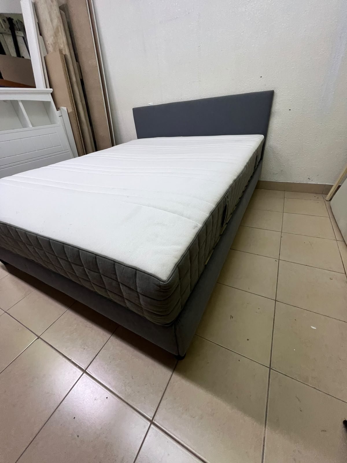 A gray upholstered bed frame with a white mattress and blanket, or a dark gray mattress on the side. - Image 10
