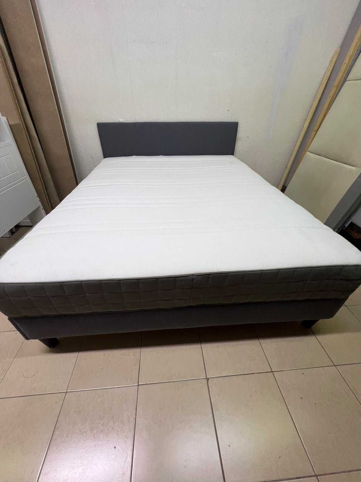 A gray upholstered bed frame with a white mattress and blanket, or a dark gray mattress on the side. - Image 12