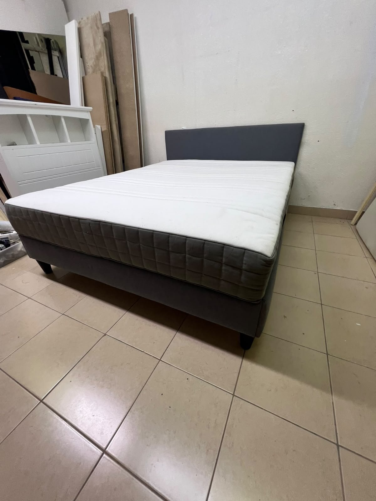 A gray upholstered bed frame with a white mattress and blanket, or a dark gray mattress on the side. - Image 13