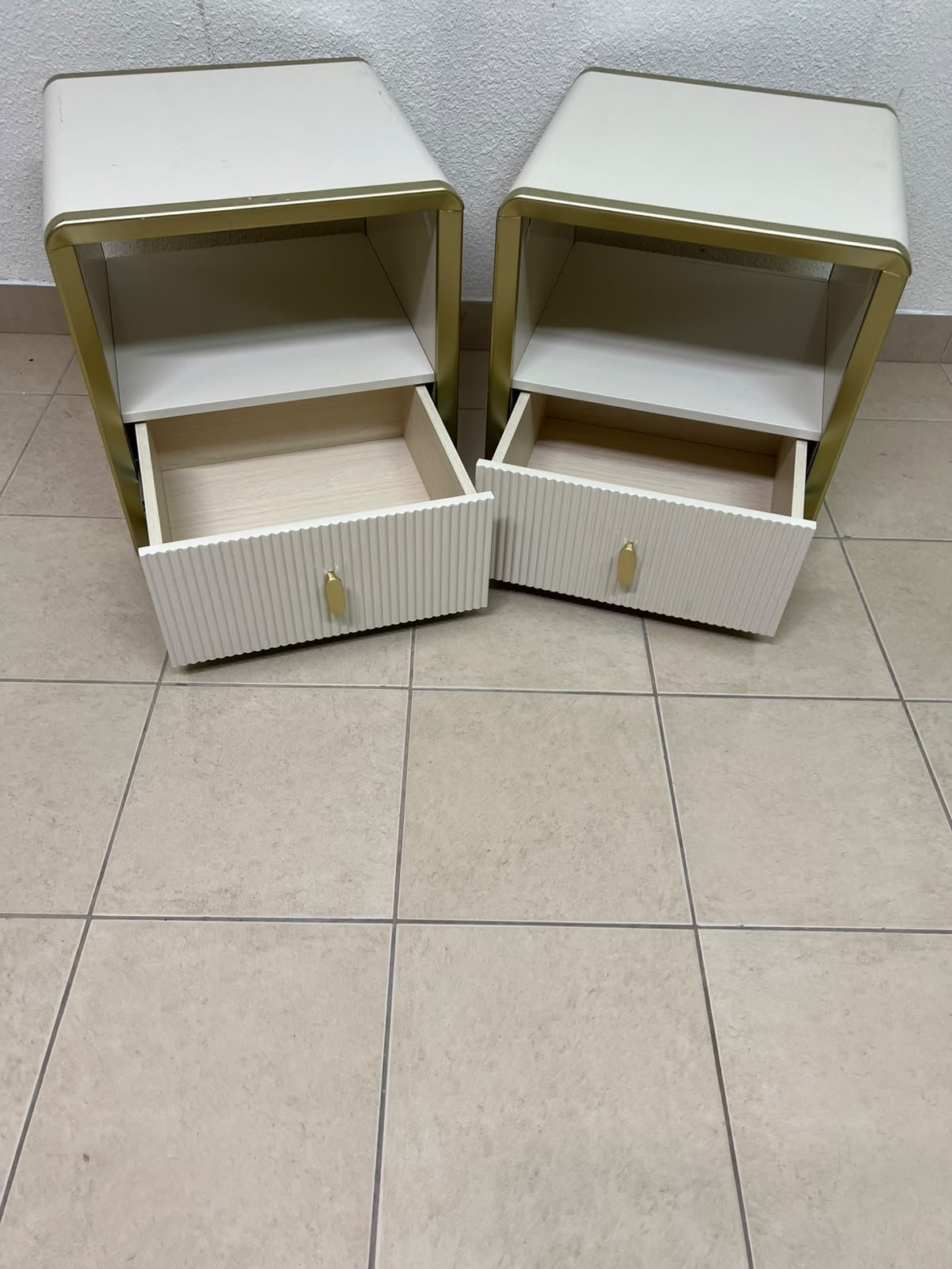 The image shows two modern bedside tables in a creamy white finish, featuring gold frames and details, as well as ribbed drawer fronts (from Home Centre). - Image 9