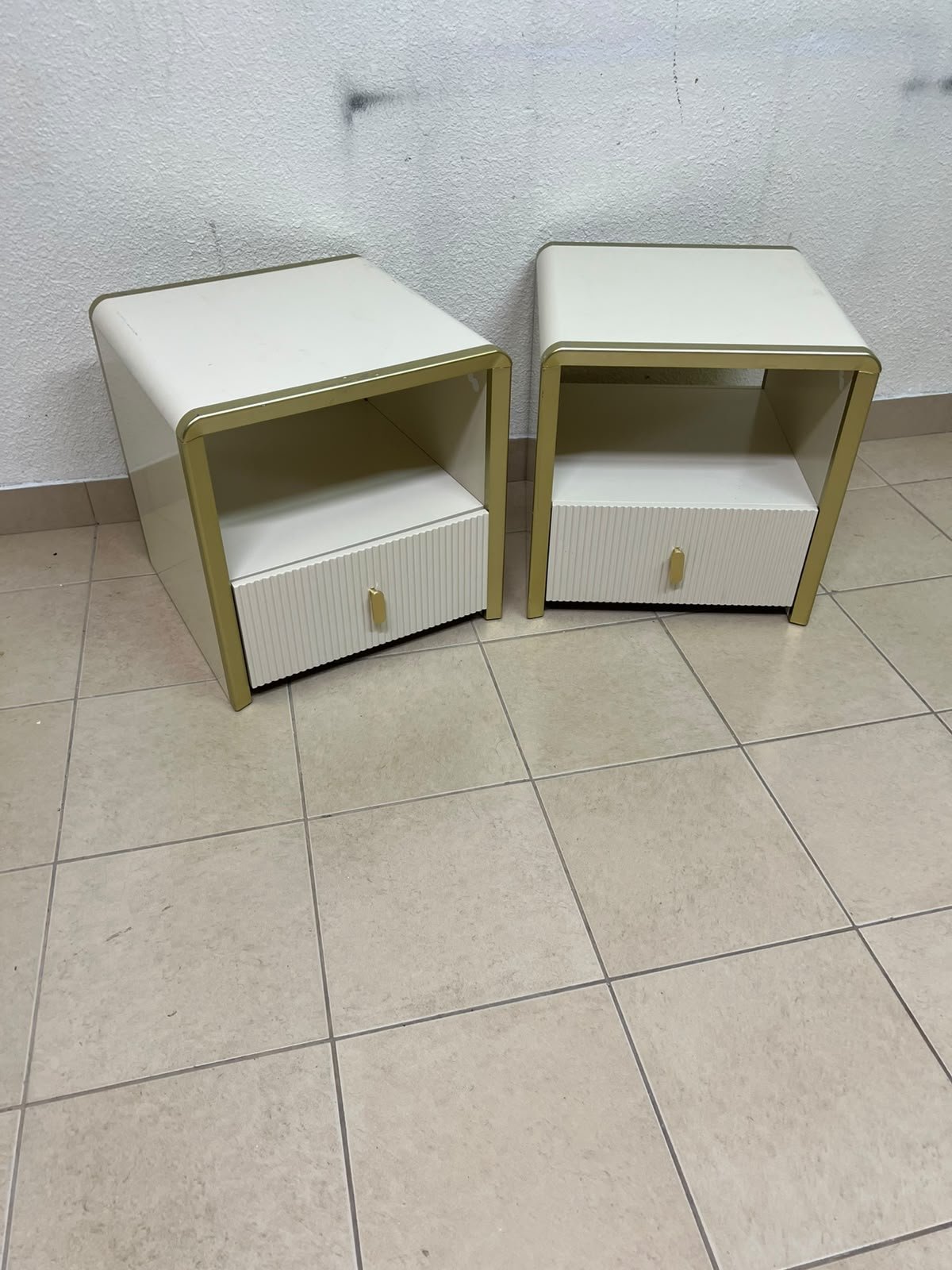 The image shows two modern bedside tables in a creamy white finish, featuring gold frames and details, as well as ribbed drawer fronts (from Home Centre). - Image 11