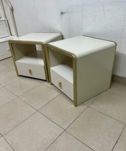 The image shows two modern bedside tables in a creamy white finish, featuring gold frames and details, as well as ribbed drawer fronts (from Home Centre). - Image 4