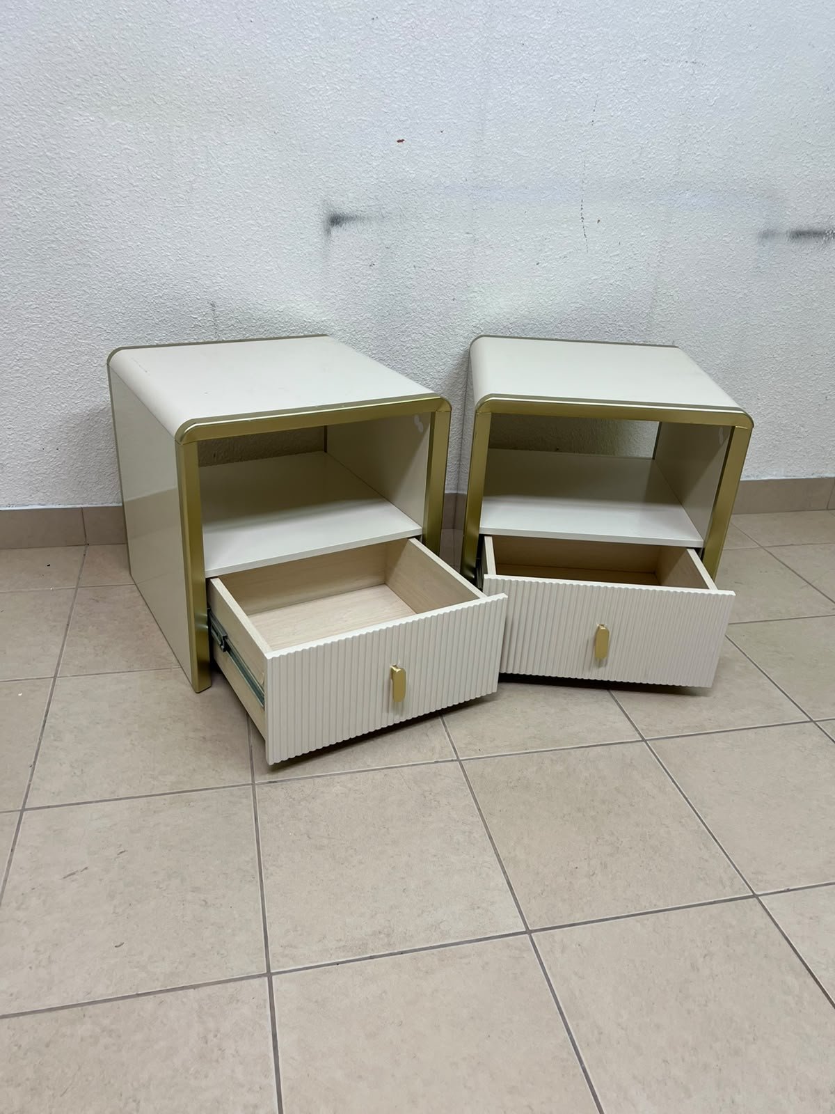 The image shows two modern bedside tables in a creamy white finish, featuring gold frames and details, as well as ribbed drawer fronts (from Home Centre). - Image 5