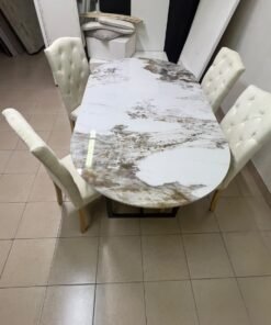 An oval dining table with a marble-patterned ceramic top, surrounded by four chairs upholstered in light beige fabric and featuring button-tufted backrests. - Image 3
