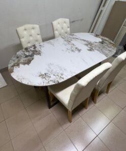 An oval dining table with a marble-patterned ceramic top, surrounded by four chairs upholstered in light beige fabric and featuring button-tufted backrests. - Image 14