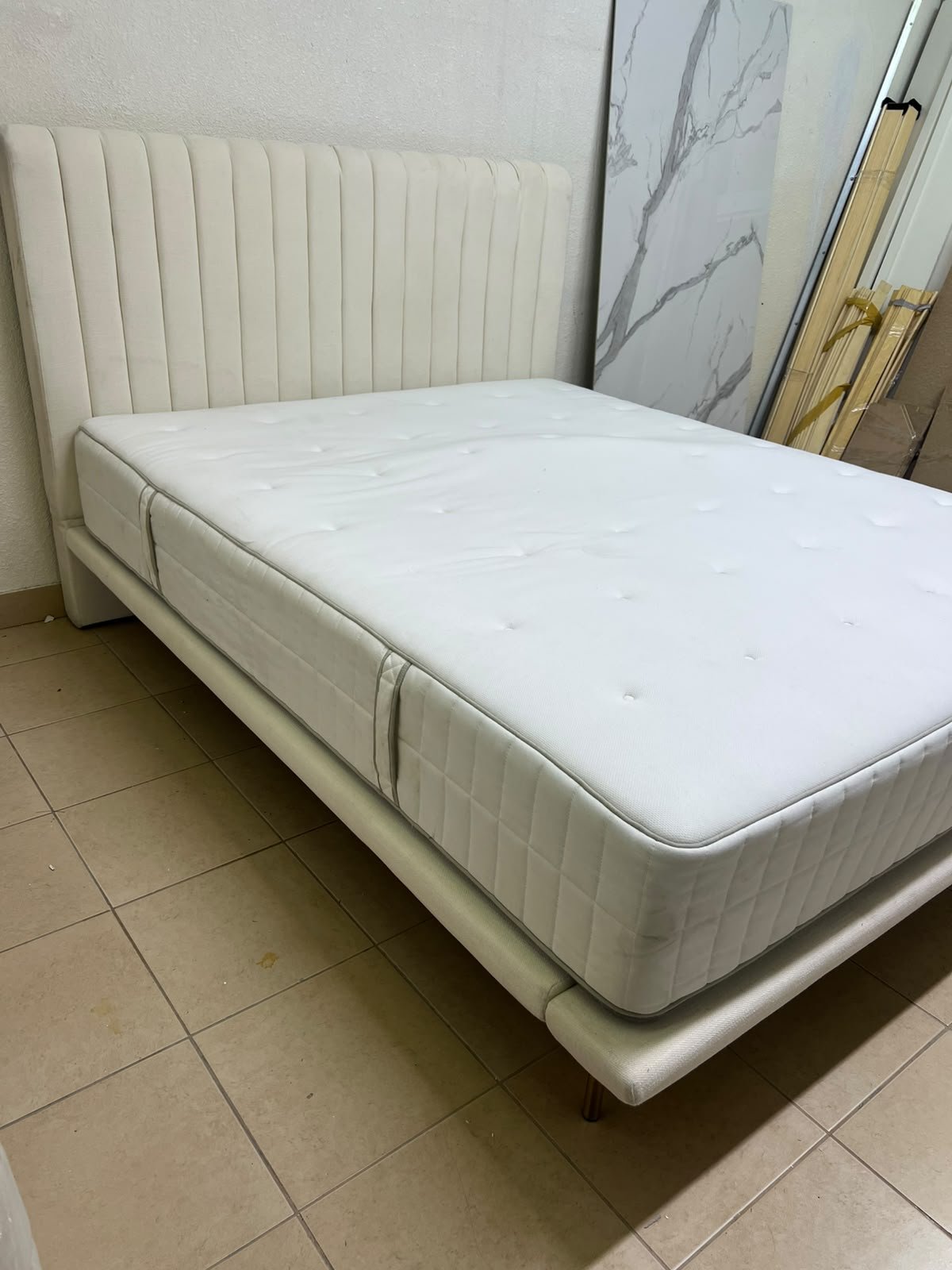 An upholstered double bed in white or light beige with a striped headboard, featuring a comfortable white mattress – Home Centre. - Image 4