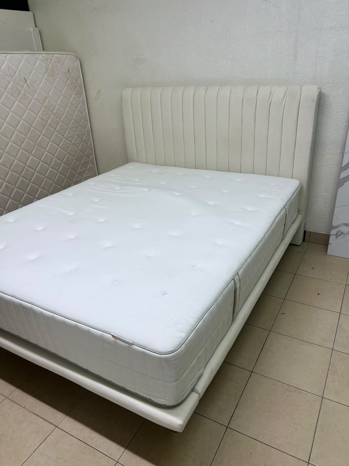 An upholstered double bed in white or light beige with a striped headboard, featuring a comfortable white mattress – Home Centre. - Image 7