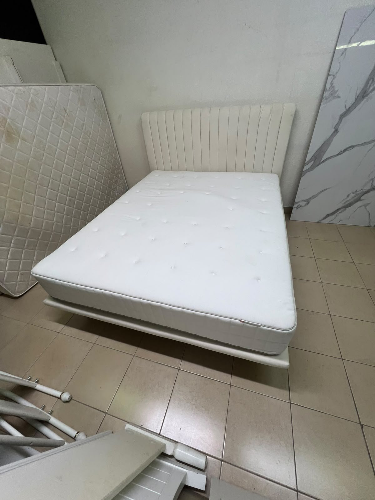 An upholstered double bed in white or light beige with a striped headboard, featuring a comfortable white mattress – Home Centre. - Image 9
