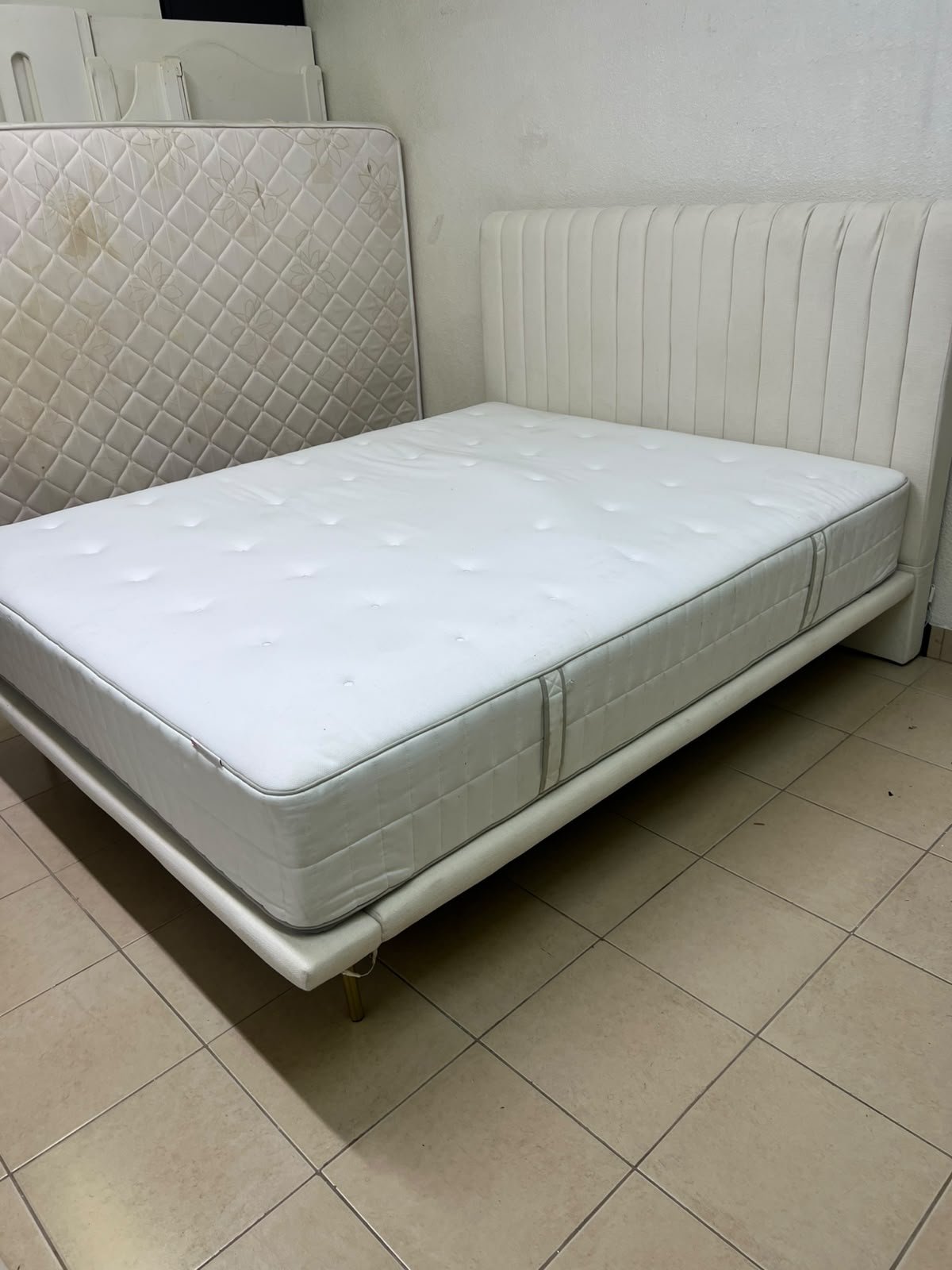 An upholstered double bed in white or light beige with a striped headboard, featuring a comfortable white mattress – Home Centre. - Image 10