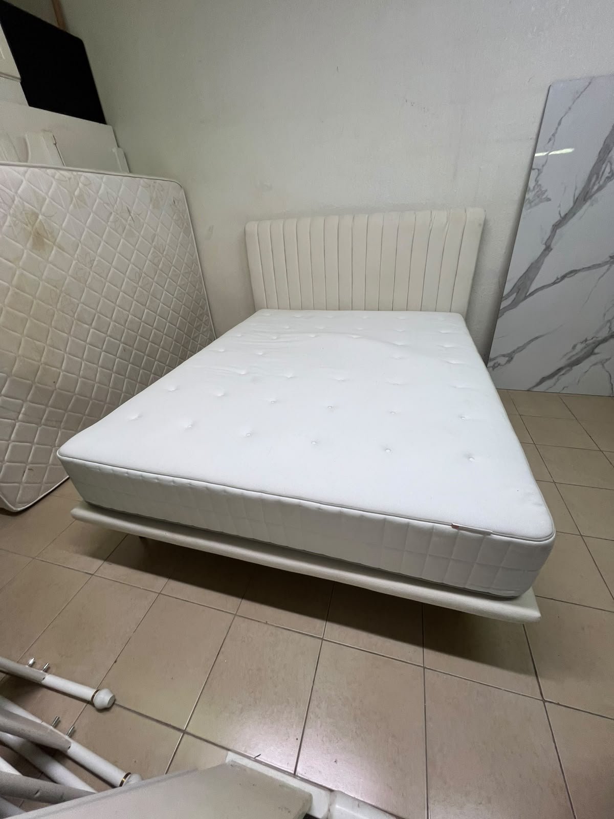 An upholstered double bed in white or light beige with a striped headboard, featuring a comfortable white mattress – Home Centre. - Image 11