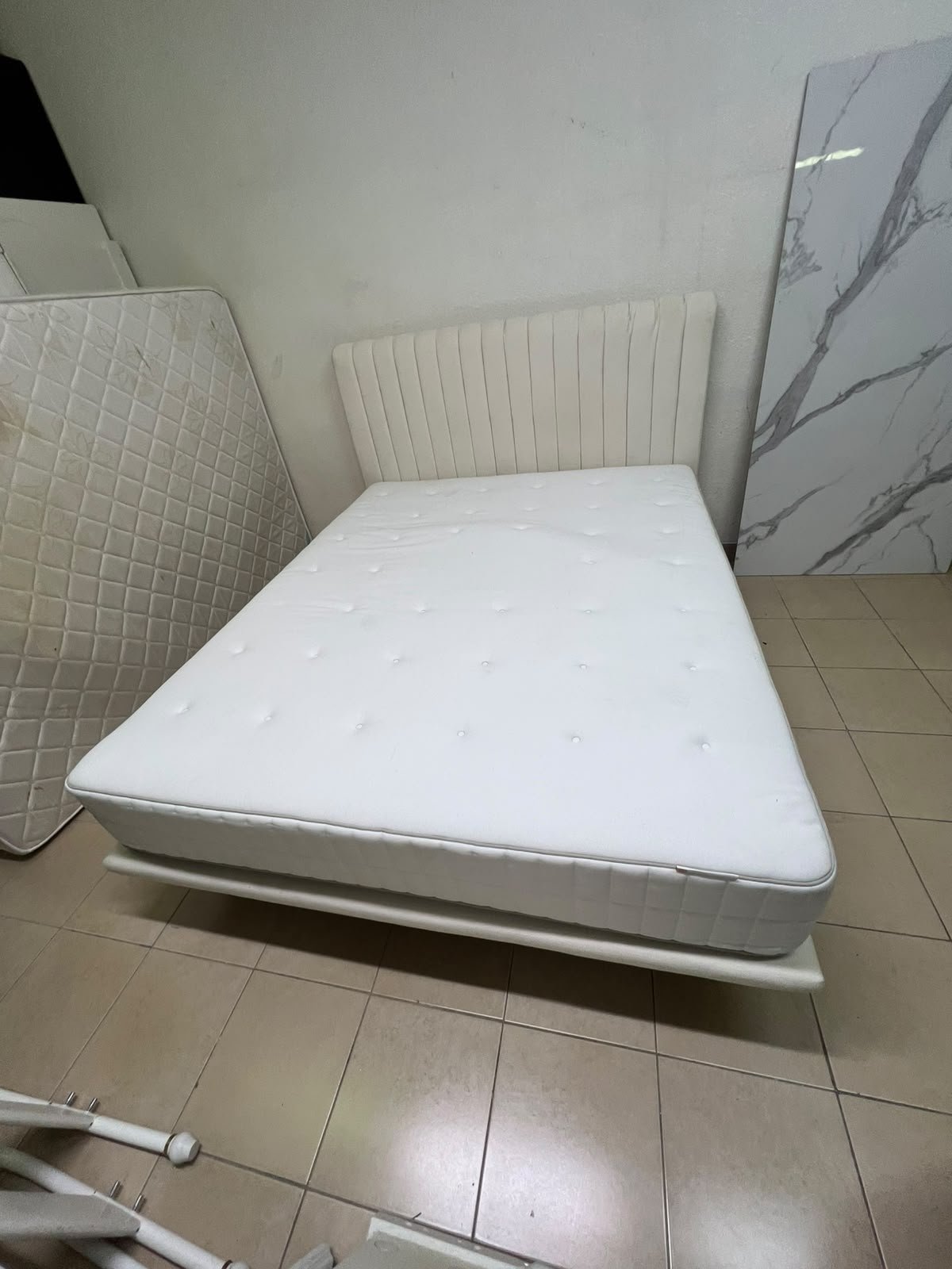 An upholstered double bed in white or light beige with a striped headboard, featuring a comfortable white mattress – Home Centre. - Image 12