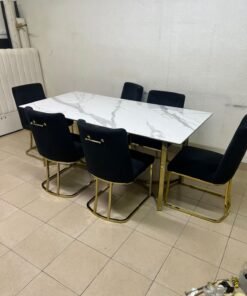 A modern six-seater dining set featuring an elegant design that combines a white marble-patterned tabletop with a gold metal base and frame, paired with black velvet chairs featuring matching gold legs. - Image 4