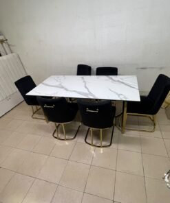 A modern six-seater dining set featuring an elegant design that combines a white marble-patterned tabletop with a gold metal base and frame, paired with black velvet chairs featuring matching gold legs. - Image 9